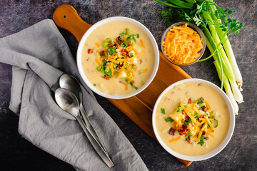 Bowls of Loaded Baked Poatos Soup Topped with Sour Cream, Cheddar Cheese, Bacon, and Chives: Creamy...