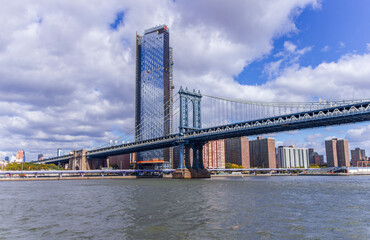 A picture of Manhattan Bridge in New York City, USA. In the picture one can see the East River, One Manhattan Square and Manhattan skyline