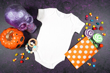Halloween theme baby romper onesie jumpsuit mockup flatlay on textured purple background with...