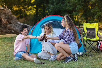 Tres personas de acampada, camping con tienda de campaña. Disfrutando, sonriendo, tocando la...