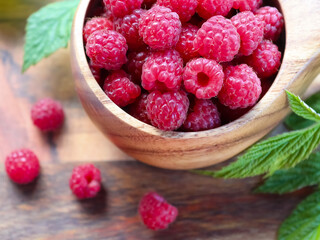 Wooden cup with wild raspberries