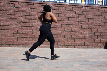 Side View On Young Nice Fat Woman In Sportive Clothes Jogging, Running Forward, Training In City Street, Concentrated On Sport Jogging, Lead Healthy Lifestyle. Weight Loss Concept. Copy Space