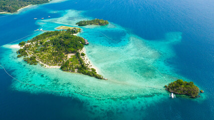 Top view of small tropical island in the blue sea with a coral reef and the beach. Malipano island, Philippines, Samal.