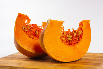 Cutted fresh orange big pumpkin on bamboo board, close up. Organic agricultural product,...
