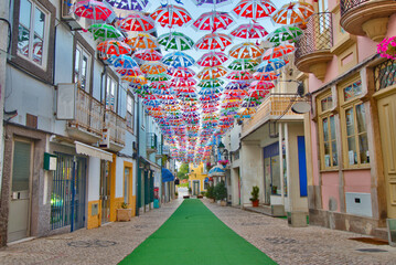 Colorful umbrellas in the street during the Agitágueda street festival in Águeda, Portugal