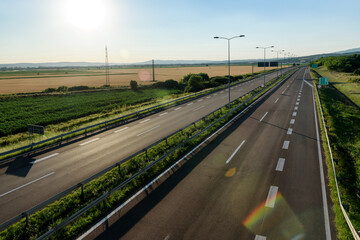 Empty silent Freeway. Asphalt highway road with beautiful sunset sky in pastoral rural environment