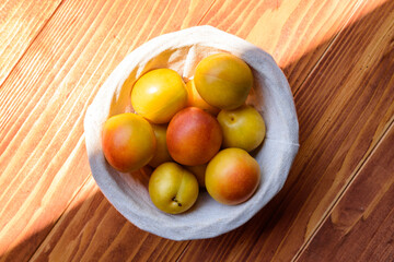 Mirabelle Plums in a basket on a wooden table. Top View

