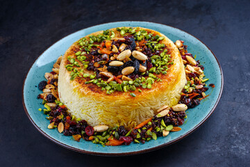 Traditional Persian tahdig jeweled javaher polow bride basmati rice with dried fruits and berries served as close-up on a Nordic design plate