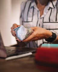 Young woman hand looking for a pencil to write on her notebook at a coffee shop. Female working indoor at cafe sitting on a wooden table. Girl working with computer. Wifi connection