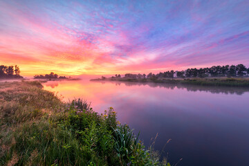 Obraz premium Colorful sunrise over the river banks