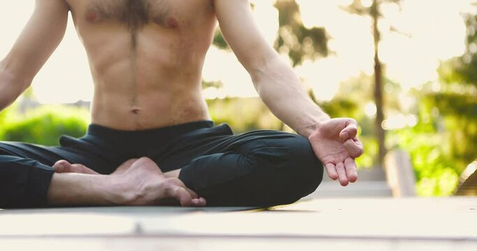 Man sitting in lotus asan,practicing yoga and mindfullness techniques.Yogi meditating in morning