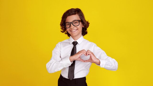 Affectionate young little boy show heart shape gesture