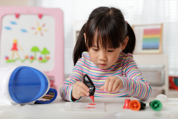 young girl making 3D shape craft for homeschooling