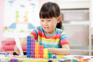 Fototapeta premium young girl play number blocks for homeschooling