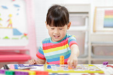 young girl play number blocks for homeschooling