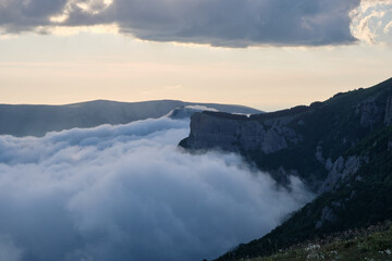 Obraz na płótnie Canvas Dense cumulus clouds cover the valley near the Demerdzhi mountain range, Crimea.