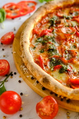 Appetizing, fresh pizza is on the table. Food from an Italian restaurant. Cooking pizza. Pizza ingredients.