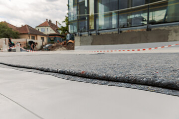 Worker prepares geotextile for the roof, covers it with synthetic PVC membrane