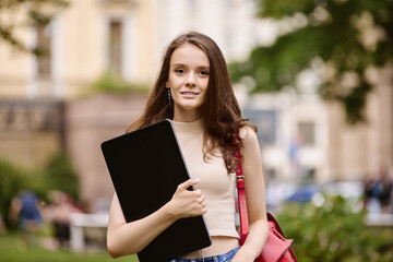 Young woman student 18 years old outside with laptop.