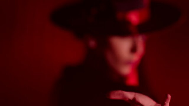 Beautiful hat dressed girl dancing latin dance . Professional female dancer dancing flamenco , rumba or salsa on red background with lines . Spanish dance movements . Shot ARRI ALEXA Cinema Camera .