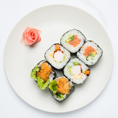 Mixed salmon Sushi rolls on plate decoraded with marinated ginger