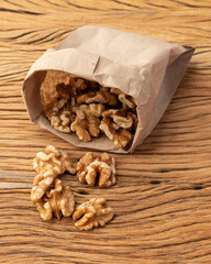 Walnuts in a paper bag over wooden table