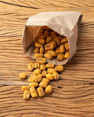 Fried corns in a paper bag over wooden table