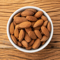 Almonds in a bowl over wooden table