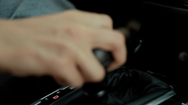 Business girl switches speed modes. Automatic transmission. Close-up shot. Hand on the lever.