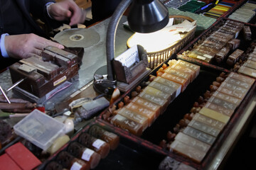 Close-up of a skilled craftsman carving an emblem stamp in Guangzhou, China.