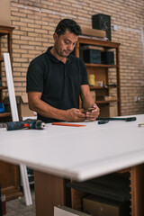 Adult man using a cellphone in a workshop