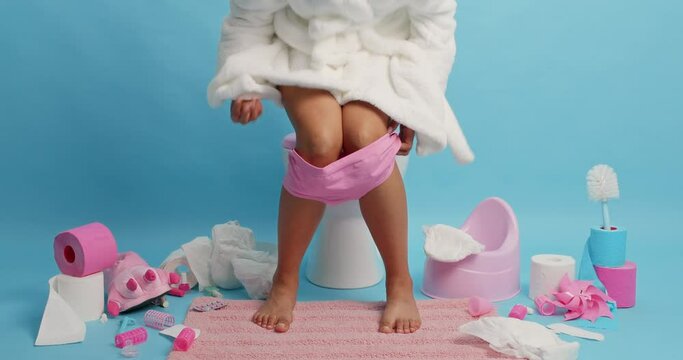 Unknown dark skinned woman in white bathrobe defecates on toilet bowl takes on panties goes away from lavatory room. Human necessities. Female model reveals herself in restroom. Sanitary concept