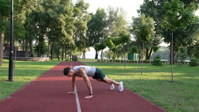 young man sportsman doing burpee exercise in park outdoor, burpee