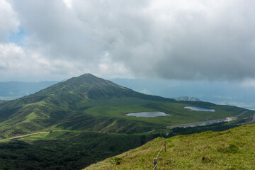 Fototapeta premium 熊本県阿蘇市の烏帽子岳、阿蘇山を登山をしている風景 Scenery of climbing Mount Eboshi-dake and Mount Aso in Aso City, Kumamoto Prefecture. 