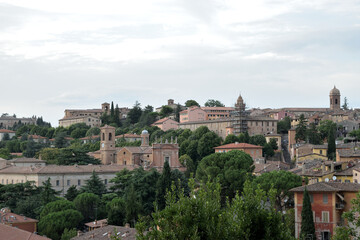 Fototapeta na wymiar scenery view of old houses in a town with a trees and part o in the back , italy , perugia city .