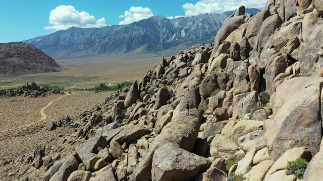 Aerial View, Lonely Woman Hiker Walking on Rock With Stunning View of Dry Desert Landscape. Alabama Hills, California USA, Drone Shot