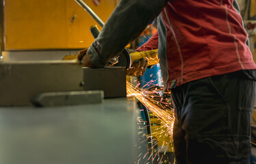 Man working on metal box showing sparks