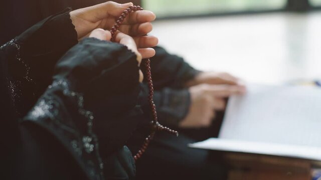 Portrait of an Asian Muslim women in a daily prayer at home reciting Surah al-Fatiha passage of the Qur'an in a single act of Sujud called a Sajdah or prostration