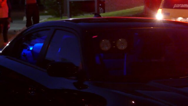undercover homicide detective car with huge flashlights, on a crime scene during the night