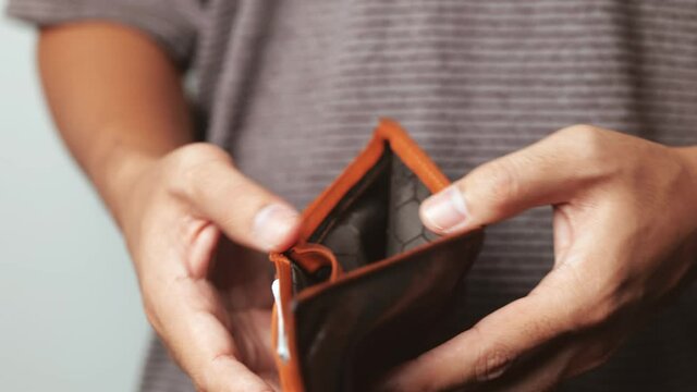 Poor man hand open empty wallet looking for money, broke, bankrupt concept 