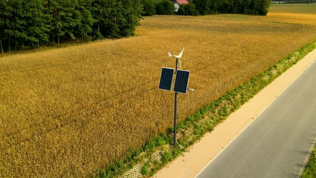 Wind generator with solar panel near the golden ripe wheat field in countryside Czeczewo, Poland