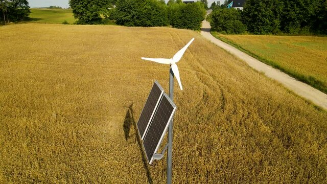 Autonomous Lighting Pole with Wind Generator and Solar Panel Near Yellow Wheat Field in Countryside Czeczewo, Poland, Aerial slide