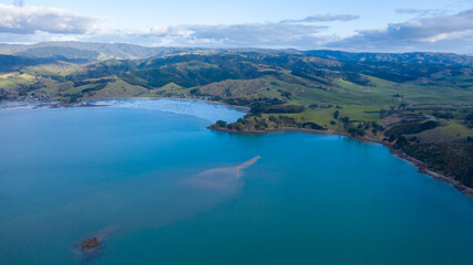 Fototapeta na wymiar Aerial View of Waitawa Regional Park, Beach, Pier, Deck Green Trees and Cliff in New Zealand - Auckland Area