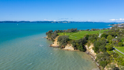 Fototapeta na wymiar Aerial View of Grahams Beach close to the park, Green Trees and Cliff in New Zealand - Auckland Area