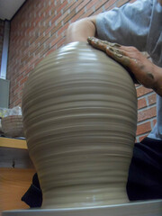 The hand of a man who makes pottery out of clay.