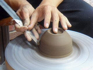 The hand of a man who makes pottery out of clay.