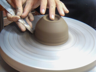 The hand of a man who makes pottery out of clay.