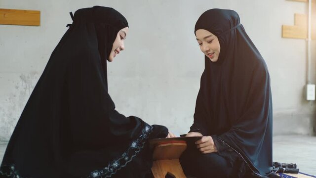 Portrait of an Asian Muslim women in a daily prayer at home reciting Surah al-Fatiha passage of the Qur'an in a single act of Sujud called a Sajdah or prostration