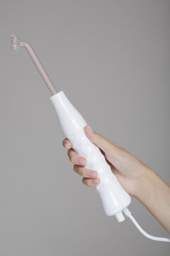 darsonval with a face nozzle in a woman's hand