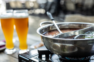Hot pot bowl with beer in restaurant sidewalk table